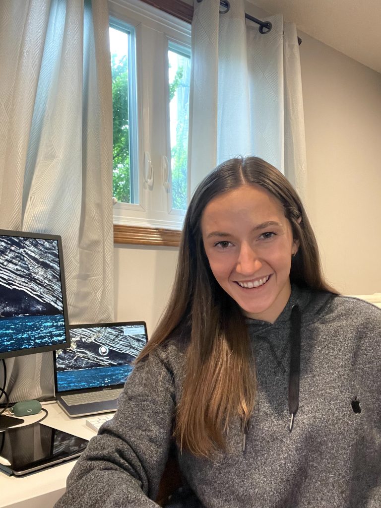 Student Riley Jackson sits in front of several computer screens.