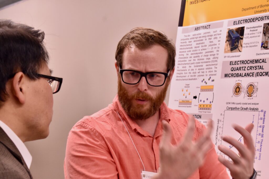 A man in glasses talks with his hands.