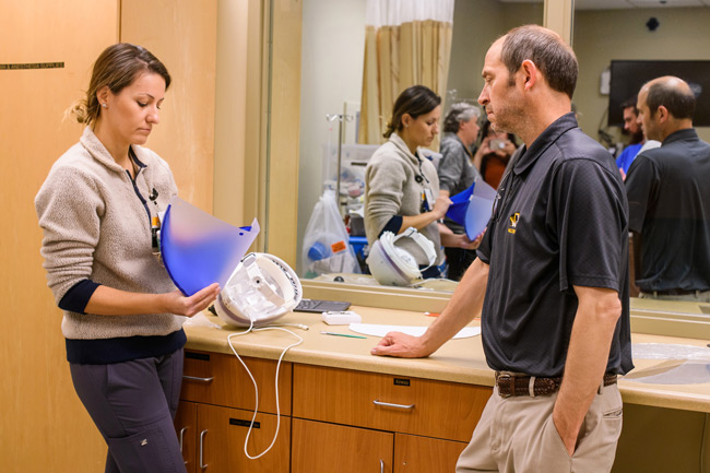 MU Health Care worker inspecting face shield