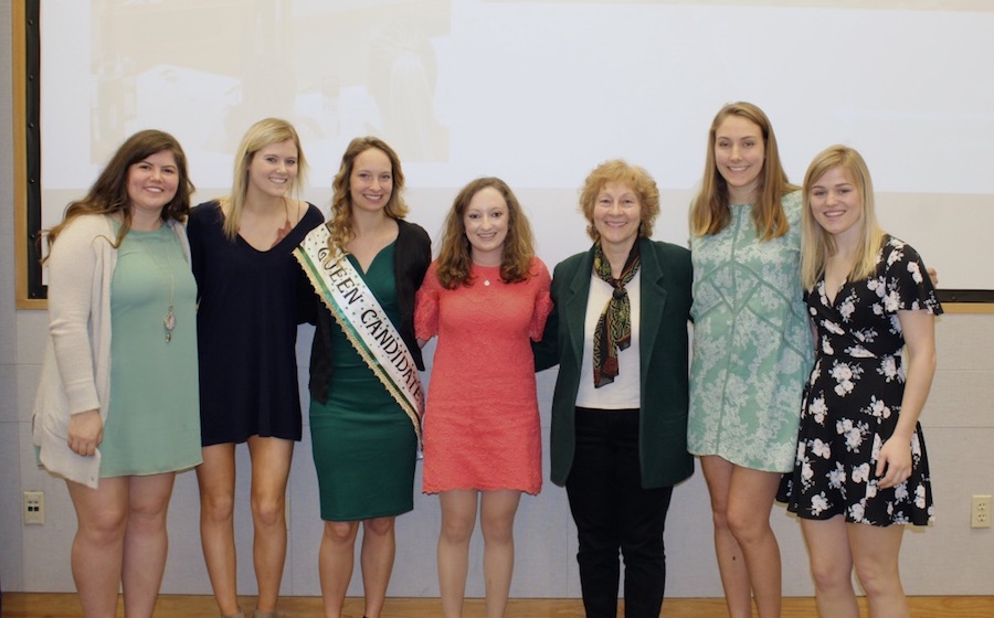 Seven women in business attire pose for a photo.