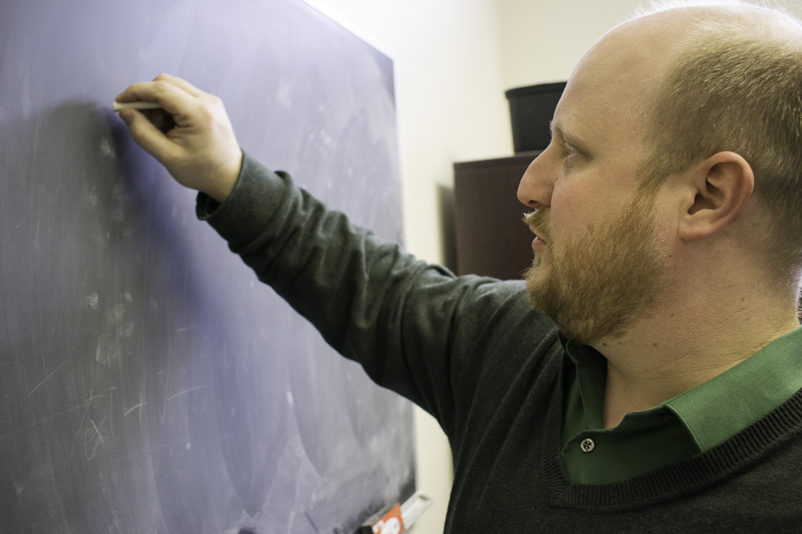 Karl Hammond writes on a blackboard.