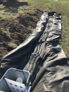 A trench draped with a device designed to spread out stormwater