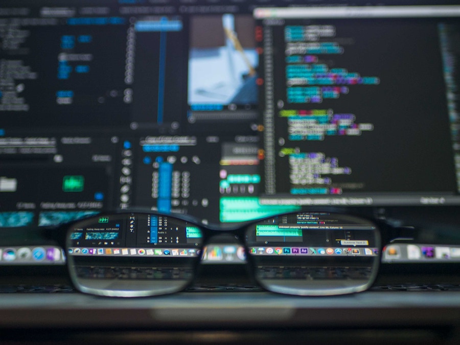 A pair of glasses sits in front of a computer screen.