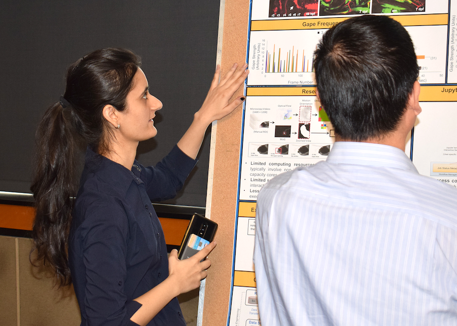 A woman shows off a poster to a colleague.