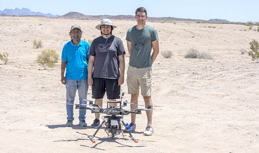 Three men with drone.