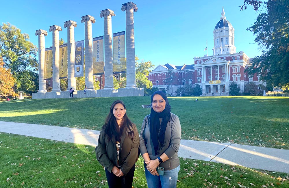 Two women in front of columns.